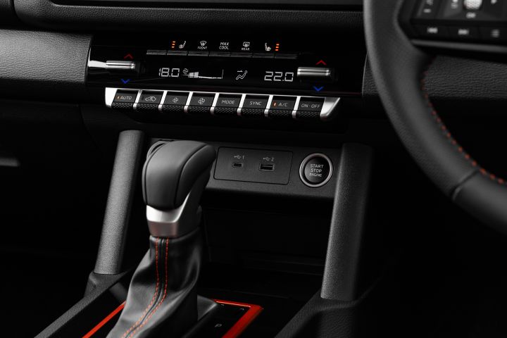 2026 Nissan Navara PRO-4X finished in Boulder Grey framing the centre stack with dual-zone climate controls, USB points, start-stop button and leather-trimmed shifter.