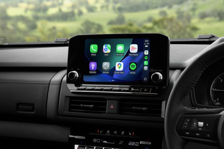 Centre dashboard view of a 2026 Nissan Navara ST-X showing the 9-inch Touch infotainment screen with the Apple CarPlay home screen, including app icons for phone, maps, messages, music, and Spotify.