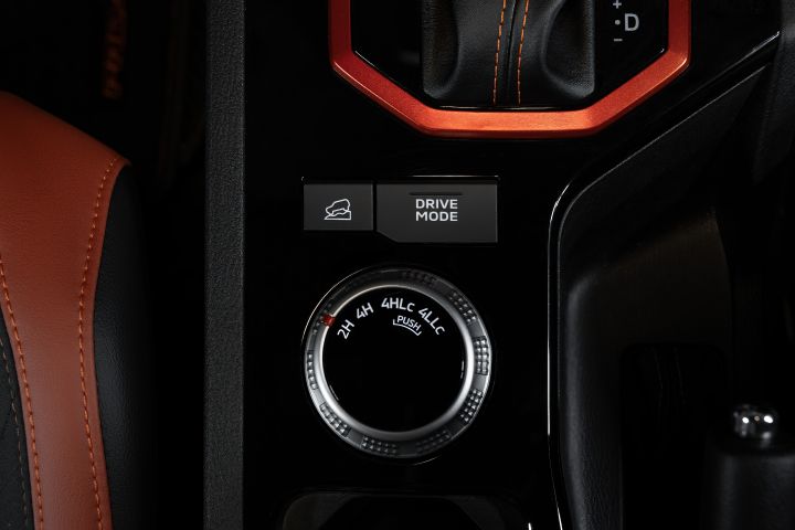 2026 Nissan Navara PRO-4X finished in Boulder Grey featuring the four-wheel-drive selector dial, hill descent button, drive mode switch and red-trimmed gearshift surround.