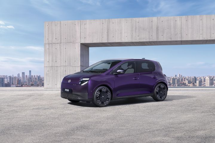 Vue avant latérale trois-quarts d’une citadine électrique Nissan PIXO violette stationnée dans un environnement urbain moderne.