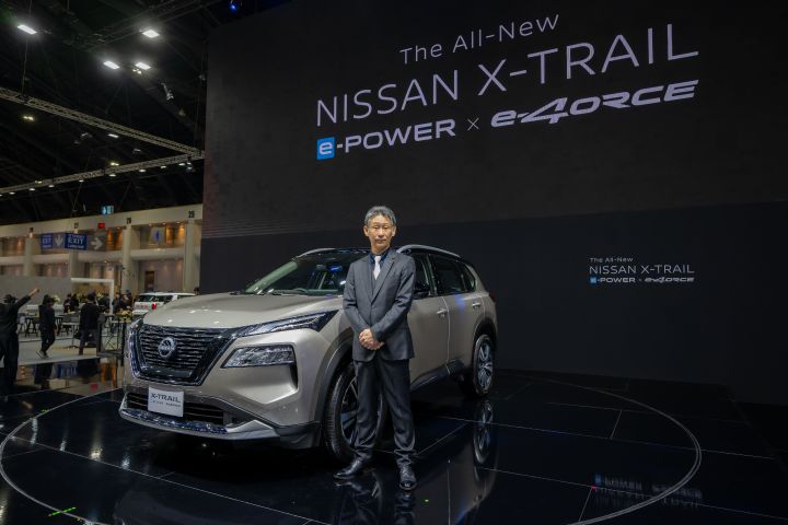 Nissan X‑Trail displayed on the stage having Nissan President posing beside the car. The LED screen at the back has the text read “The All-New Nissan X‑Trail e‑POWER with e‑4ORCE’