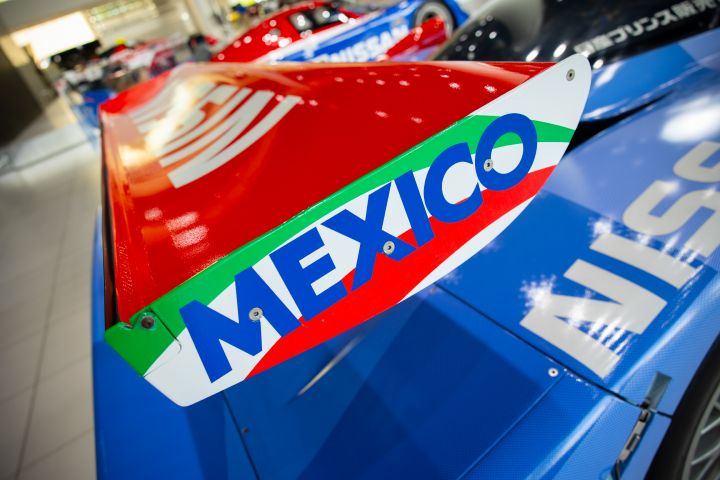 A close up of the red rear aero spoiler installed on a blue Nissan R390 GT1 Le Mans race car.