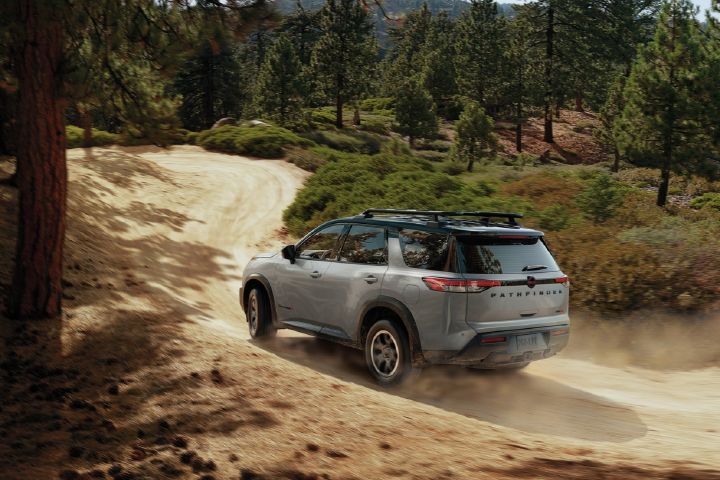 A Nissan Pathfinder curving up a dirt hill.