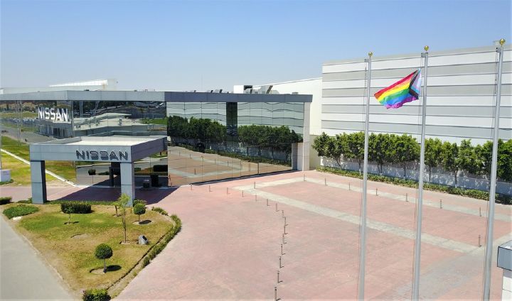 Bandera de orgullo LGBT con las oficinas de Nissan de fondo