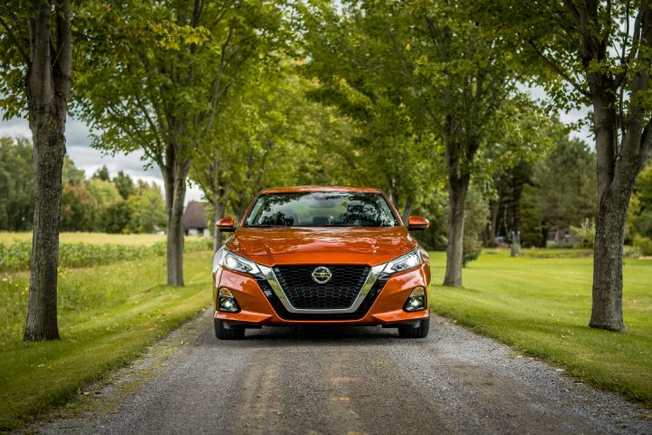 A 2020 Nissan Altima driving down a dirt road.