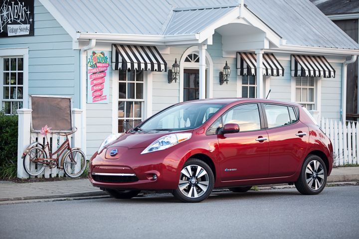 a red 2013 Nissan LEAF parked outside a store