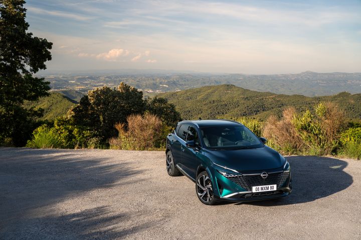 Statische 3/4 Frontansicht aus leicht erhöhter Position eines dunkelgrün-blauen Nissan Qashqai mit e‑Power-Antrieb der nächsten Generation