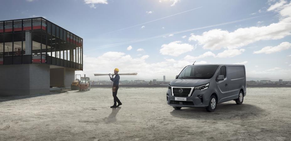 Veículo comercial Nissan PRIMASTAR em zona de obras, com trabalhador ao lado a transportar material