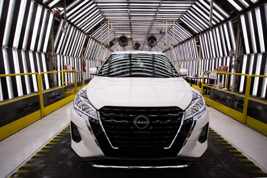Nissan Kicks Play Sense de frente na cor branca dentro do túnel de luz na fábrica de Resende