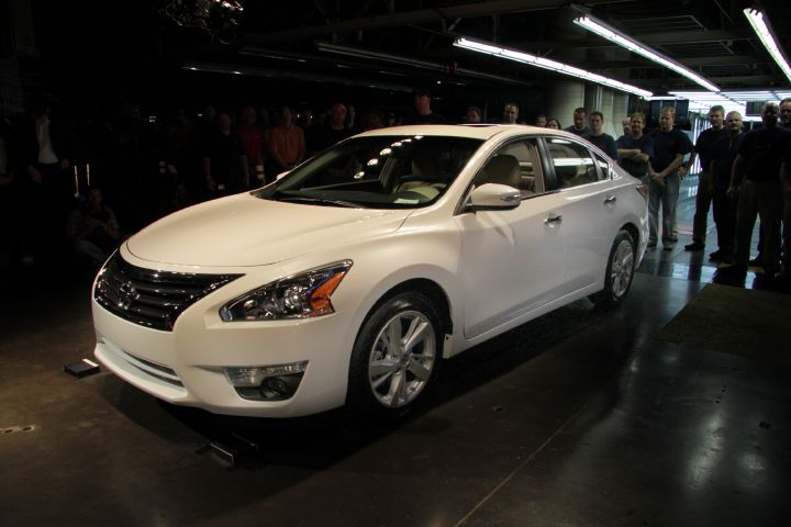 People standing behind 2013 Nissan altima