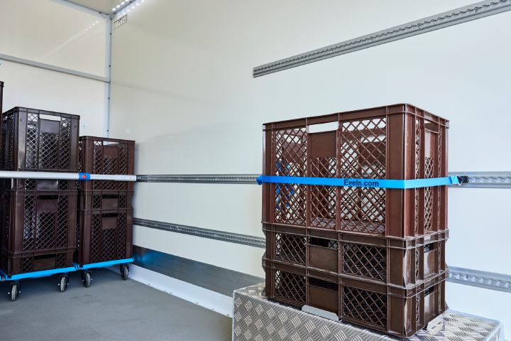 Der Radkasten im Inneren des Nissan Interstar-e mit Bäckereikoffer ist mit einer Metallabdeckung verkleidet, darauf stehen braune Bäckerkörbe