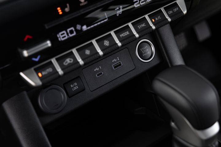Lower centre stack detail in a 2026 Nissan Navara ST-X showing the Start Stop Engine button, USB-C and USB-A ports, the rear differential lock switch, and part of the automatic gear selector.