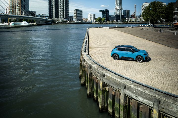 Ein blauer Nissan Micra steht an einer sonnenbeschienenen Kaikante in Rotterdam