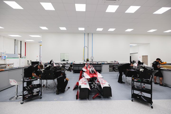Boxenarea im Nissan Formel E Headquarter mit Mechanikern und Nissan Formel E Rennwagen