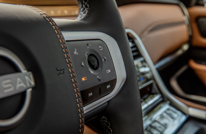 The right side of the steering wheel and controls inside the 2025 Nissan Armada, tan interior can be seen behind.