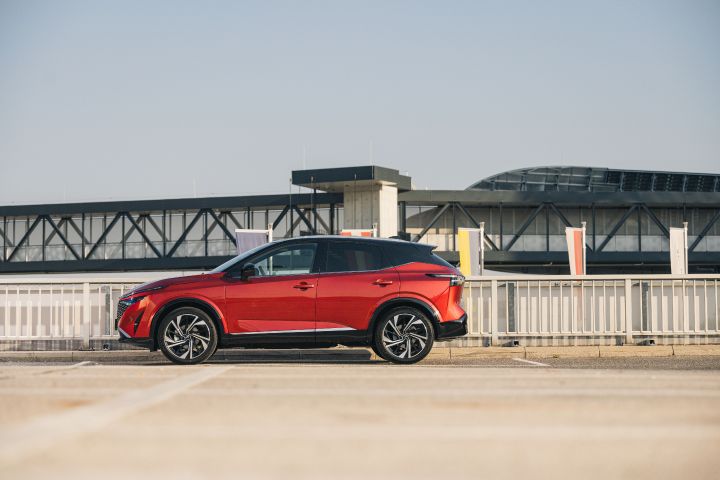 Seitenansicht eines stehenden Nissan Qashqai in Fuji Sunset Red