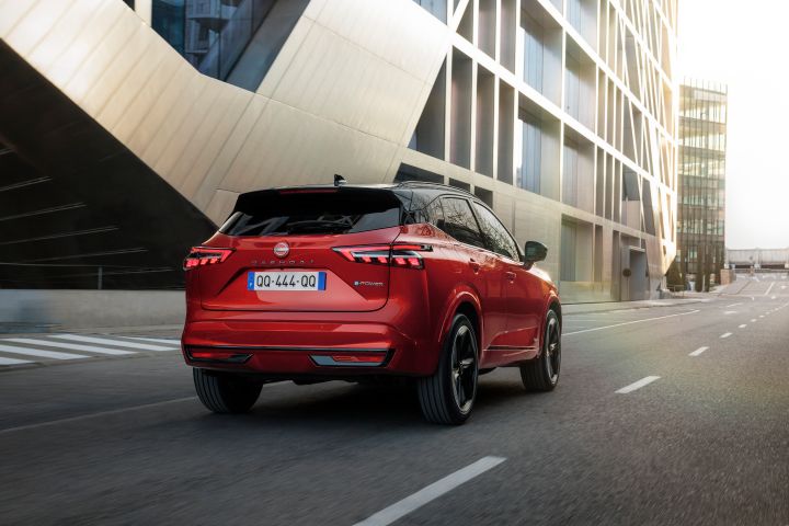 Nissan Qashqai rouge Fuji de ¾ arrière roulant dans un environnement urbain