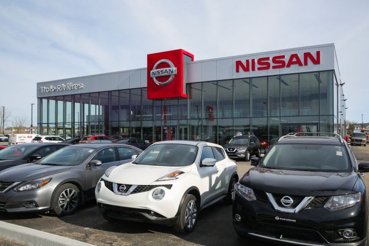 Vue d'un concessionnaire Nissan présentant des voitures devant.
