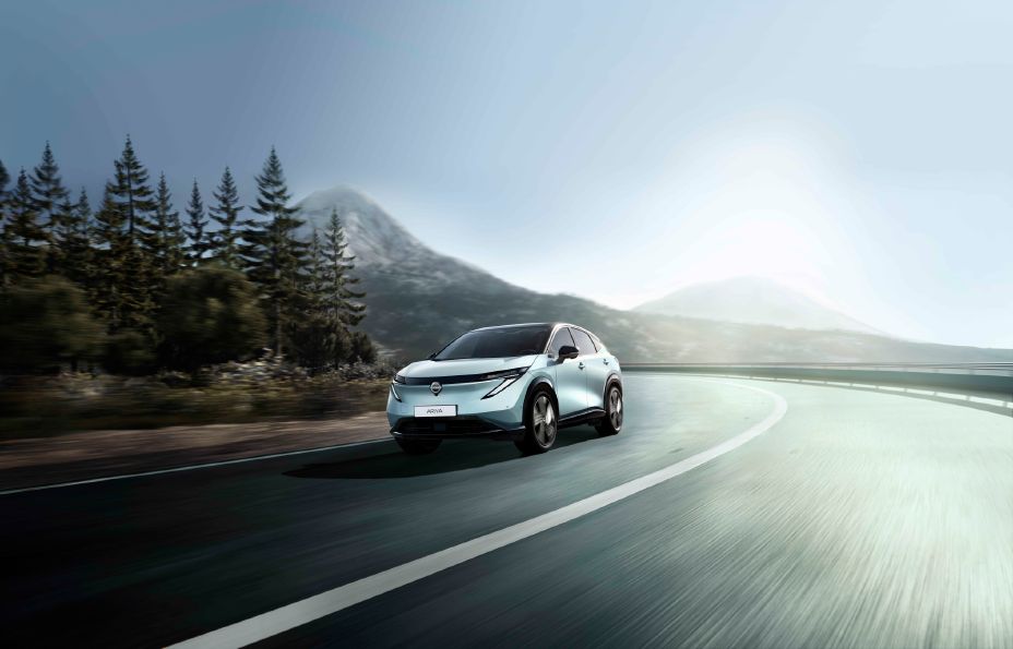 Opdateret Nissan Ariya kørende i skoven, hvor man kan se den coupe inspirerede SUV profil.