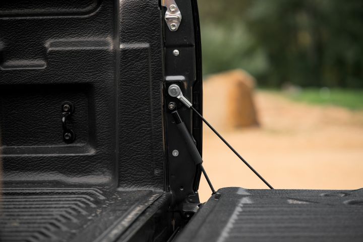 2026 Nissan Navara PRO-4X finished in Boulder Grey highlighting the open tub’s tailgate damper, support cable and textured liner detail.