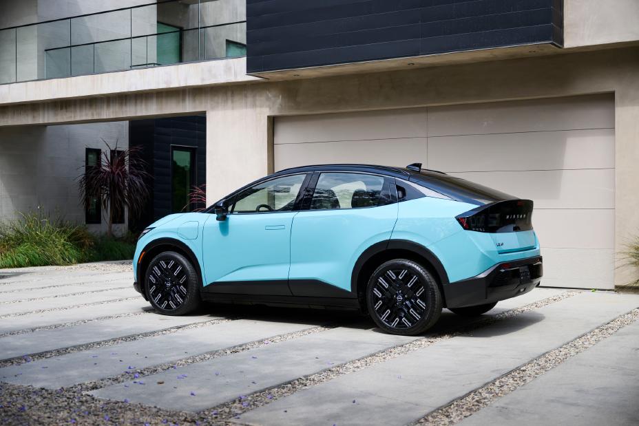 profile view of the 2026 Nissan LEAF parked in front of a garage attached to a modern house.