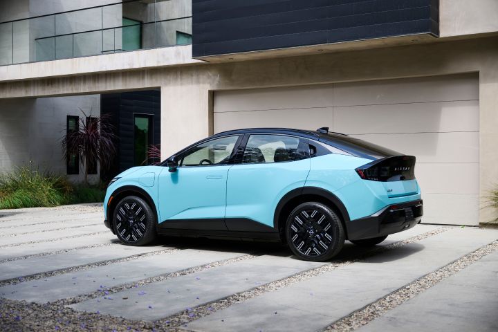 profile view of the 2026 Nissan LEAF parked in front of a garage attached to a modern house.