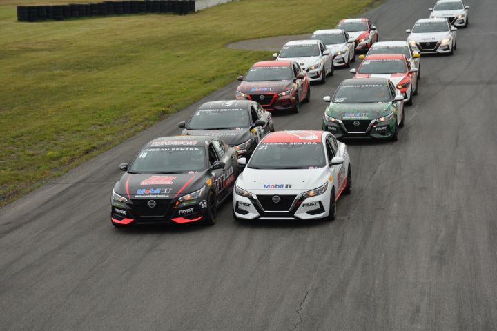 Group of Sentra Cup cars driving down the track.