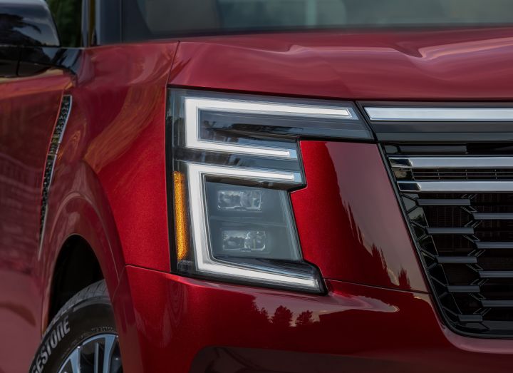 Close up of the angular head light on a red 2025 Nissan Armada.