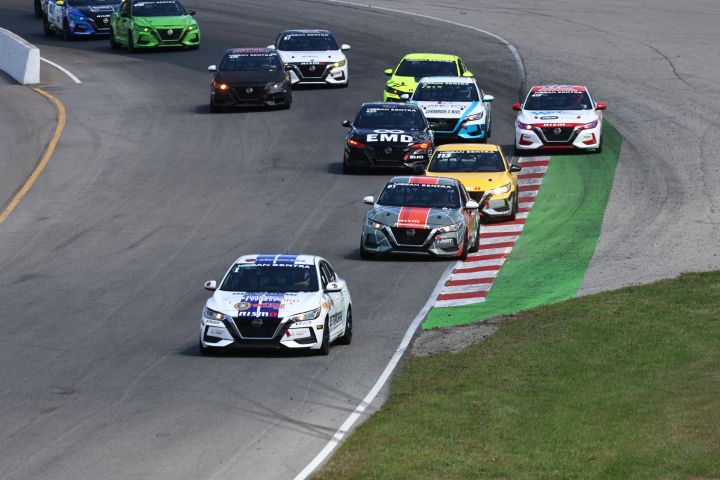 Several race cars driving on a race track