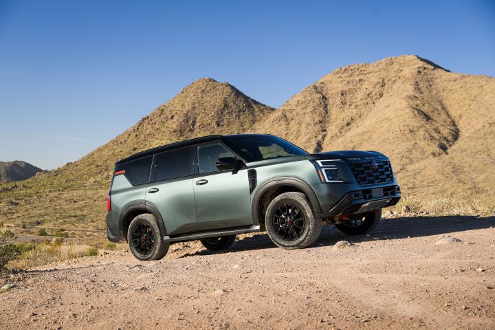 Angled side view of a 2025 Nissan Armada PRO-4X parked on a rocky hill in the desert.
