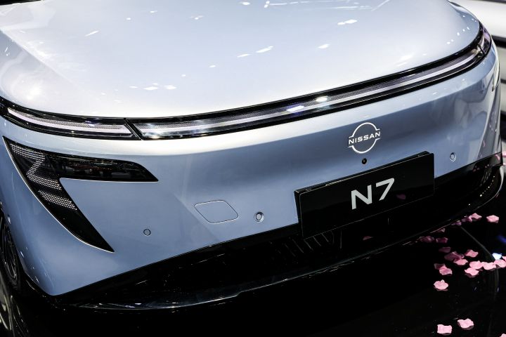 東風日産の白い新型セダン電気自動車「N7」のフロントクローズアップ。ライト、日産バッジ、N7ネームプレートが見える。