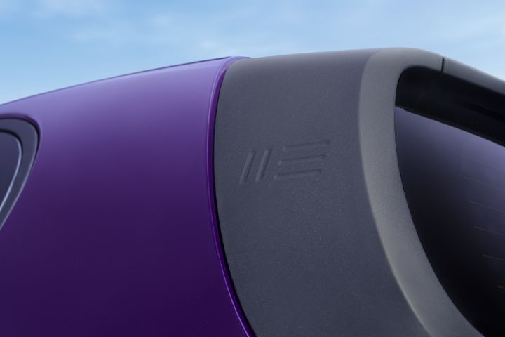 Nærbilde av Nissan PIXO takspoiler, som viser en preget geometrisk designdetalj som betyr «Nissan» i det lilla karosseriet.