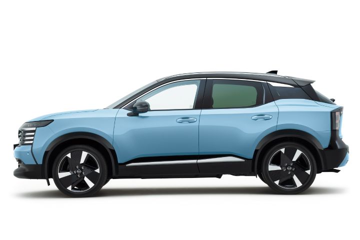 Side view of a bluish Nissan Kicks. The vehicle faces right, with body lines and black roof accentuated against a white background.