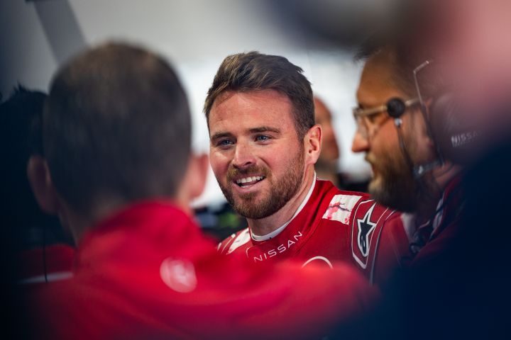 Oliver Rowland lächelt, während er mit Nissan Ingenieuren spricht