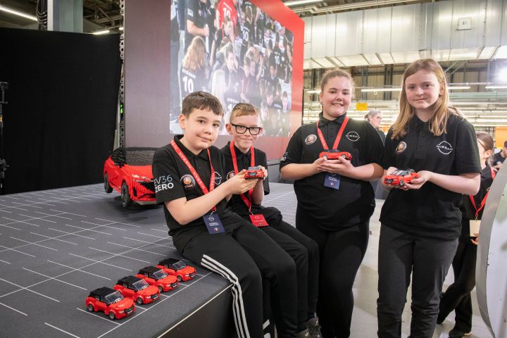 Four kids holding Nissan Lego Qashqai they built with a bigger Nissan Lego Qashqai in the background