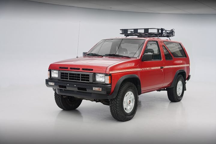 Nissan Pathfinder 1990 roja con franja blanca, portamaletas. En fondo blanco