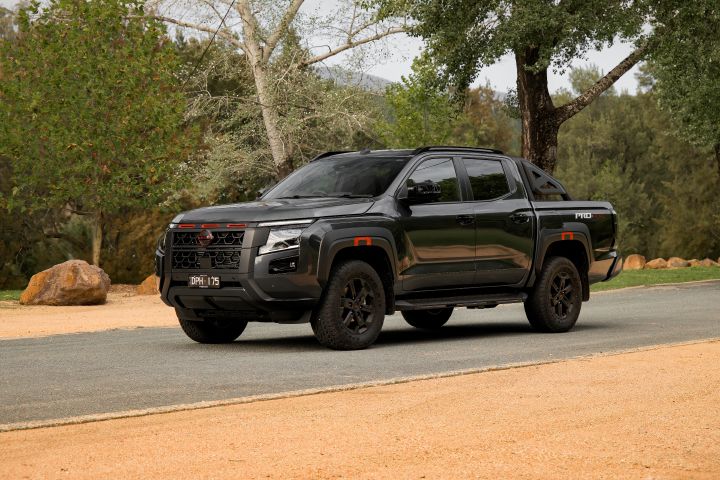 2026 Nissan Navara PRO-4X finished in Boulder Grey shown in a full front-side exterior view with black wheels, red accents and sports bar.