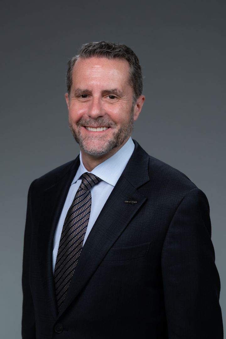 Portrait of Andrew House (suit, tie, NISSAN corporate pin) (smiling)