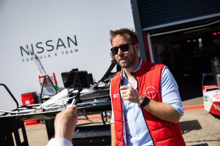 Sam Bird mit Sonnenbrille und einer roten Teamweste bei einem Interview