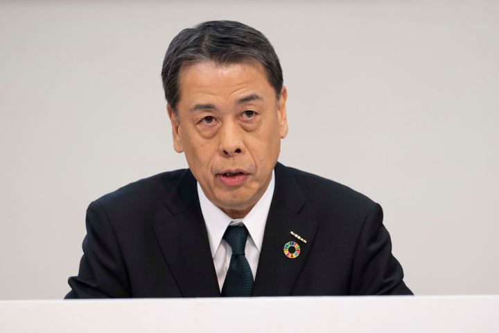 Makoto Uchida hablando, vistiendo un traje negro con camisa blanca.
