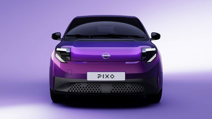 Foto, das ein violettes Elektrofahrzeug der Marke Nissan in Frontansicht zeigt. Die schlanken Scheinwerfer, der schwarze Kühlergrill, das Nissan-Emblem und das Nummernschild mit der Aufschrift „Pixo“ heben sich deutlich vom lavendelfarbenen Studiohintergrund ab.