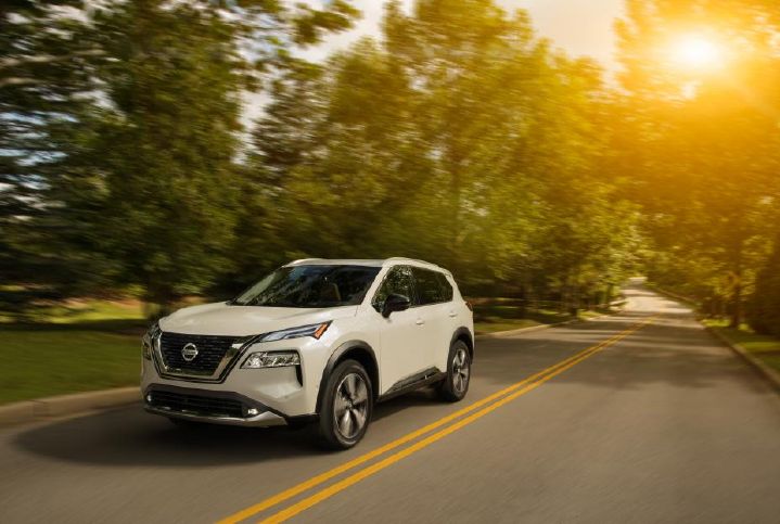 Front left view of the 2021 Nissan Rogue driving down the road.