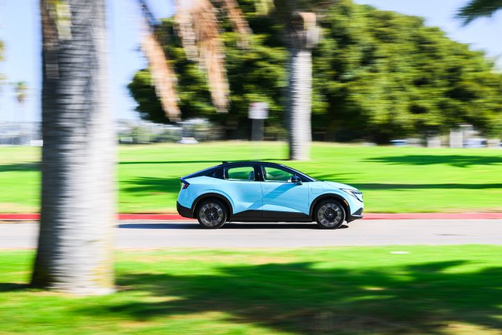 Right profile view of the 2026 Nissan LEAF driving along an empty street.