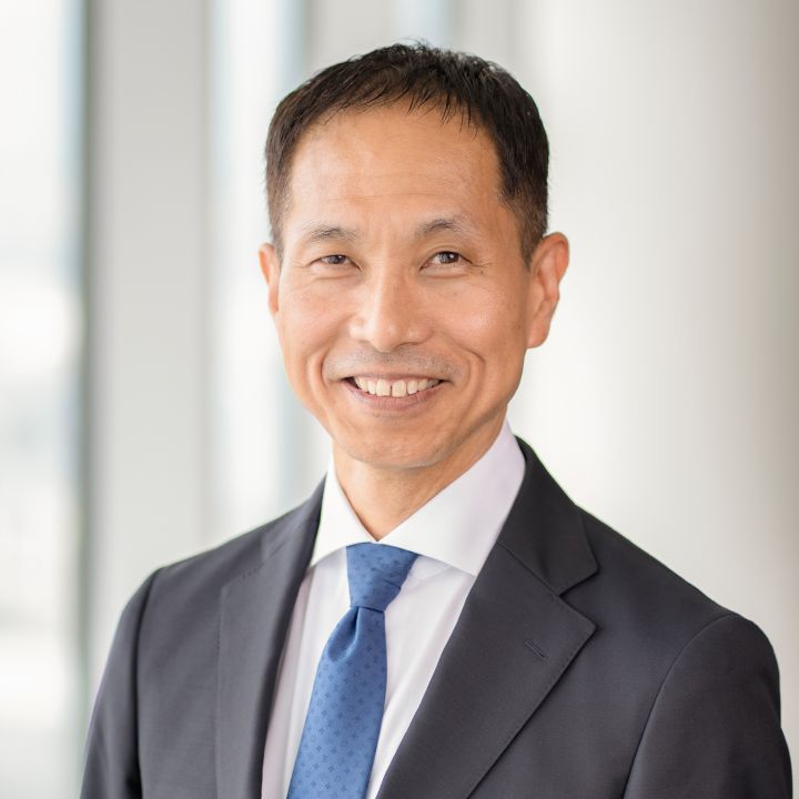 Portrait of Toru Ihara with navy blue suit, tie and NISSAN corporate pin (smiling)