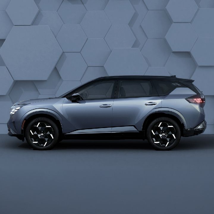 One Nissan Rogue Hybrid e‑POWER side view in front of a backdrop that looks to have tiles.