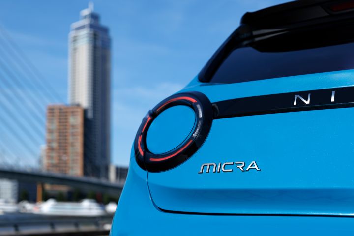 Detailaufnahme von Rückleuchte und Micra Logo am Heck, im Hintergrund ist unscharf ein Hochhaus in Rotterdam zu sehen
