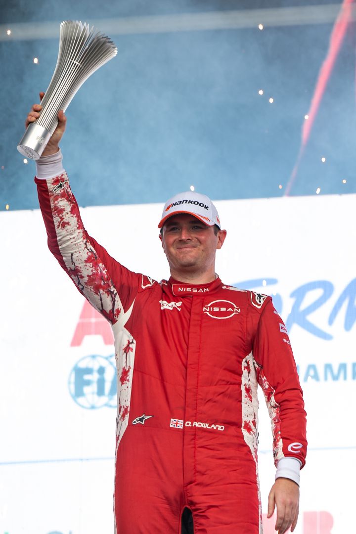 Oliver Rowland steht lächelnd auf dem Podium in São Paulo und hält seinen Pokal für den zweiten Platz hoch.