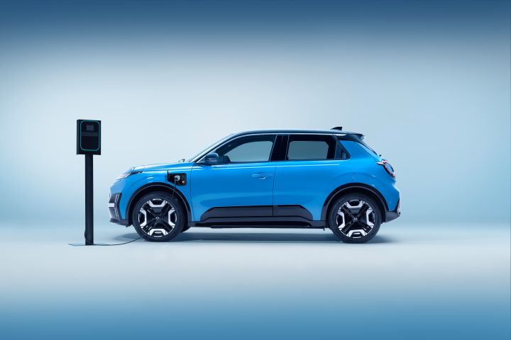 profile view of new Micra in blue gear body color & black roof connected to a black charging outlet