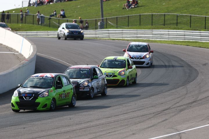 Five Micra Cup cars rounding a turn while racing.