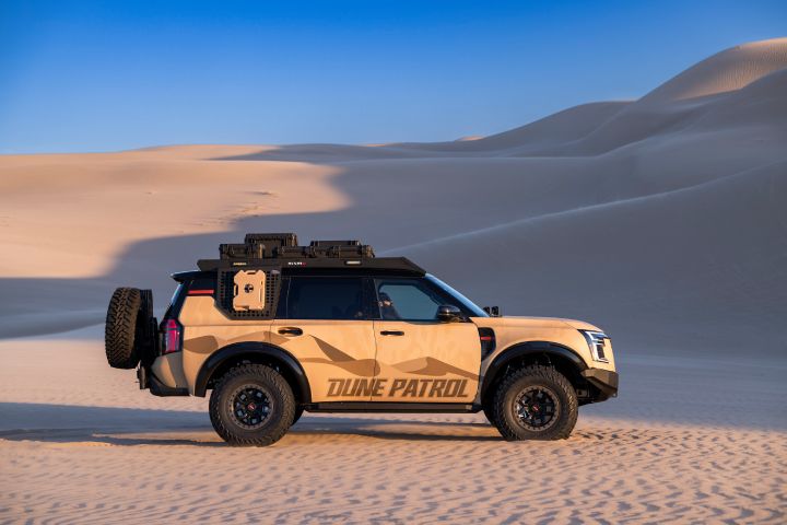 Right profile view of the Nissan Dune Patrol SEMA build parked on sand dunes.